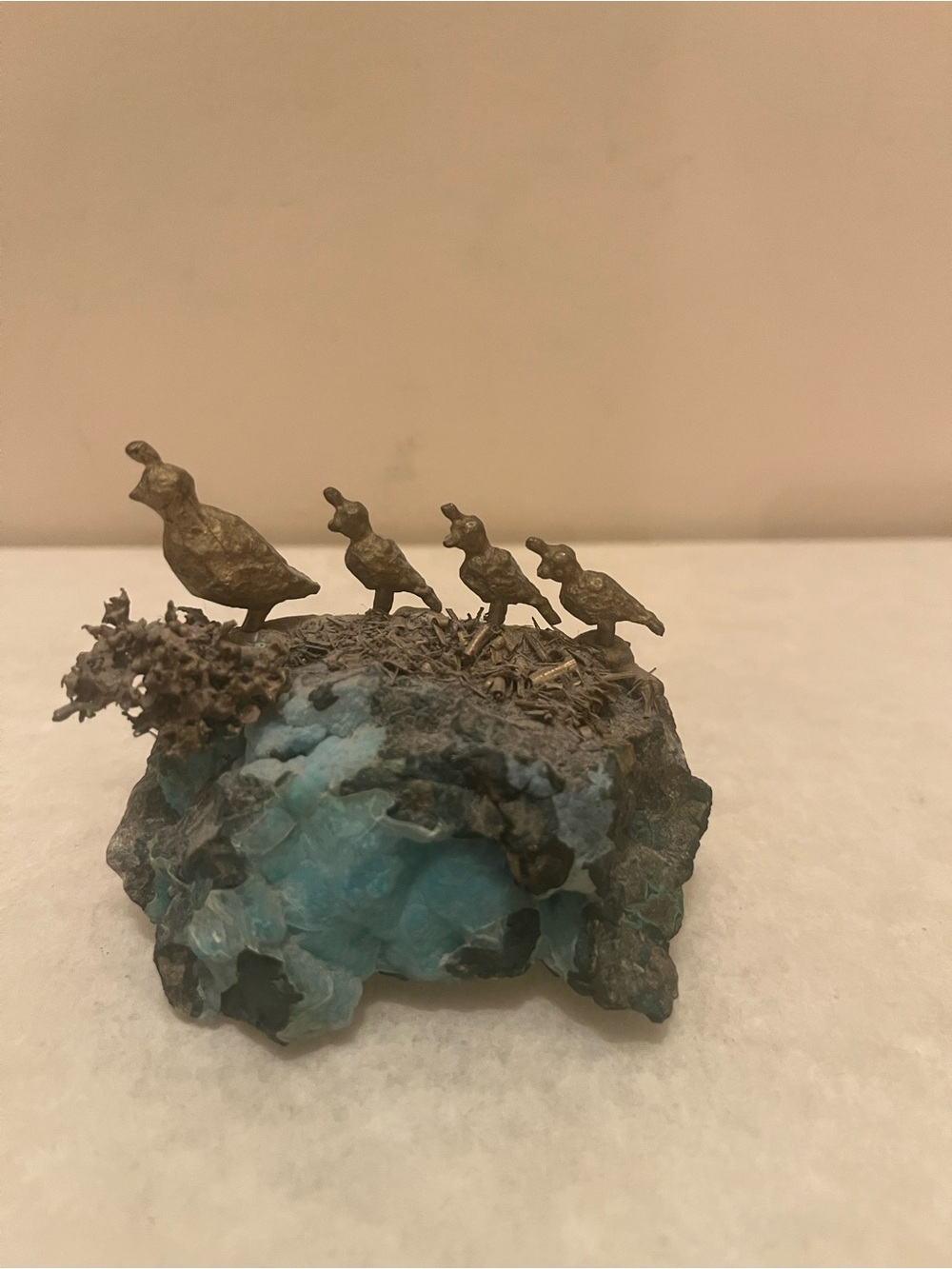 bronze sculpture of a covey of quail (an adult and three chicks)